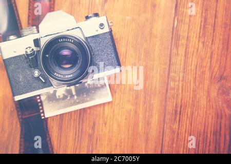 Alte Retro-Kamera mit altem Bild auf Holzoberfläche Stockfoto