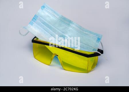 Maske und Schutzbrille für persönlichen Schutz auf hellgrauem Hintergrund Stockfoto