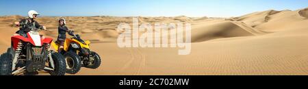 Quad ATV fährt Menschen. Glücklich lächelnd paar Biker in Sandwüste. Quad fahren und Skidmarks in Panorama-Sanddünen Wüste. Afrika, Namibia, Namib Stockfoto