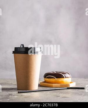 Kalter schwarzer Kaffee mit Eiswürfeln in hohem Glas und frischem Croissant. Erfrischendes Kaffeegetränk auf einem grauen Hintergrund. Stockfoto