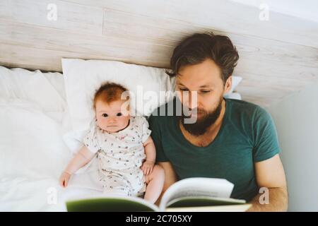 Vater und Baby Tochter Buch lesen Märchen zu Hause Lifestyle Papa Lehre Kind Kind Kind Eltern Kindheit Bildung Konzept Väter Tag Urlaub Stockfoto