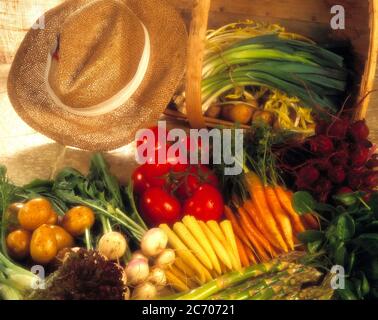 Auswahl an frischem Gemüse mit Strohhut, hessischer Hintergrund weicher Fokus Stockfoto