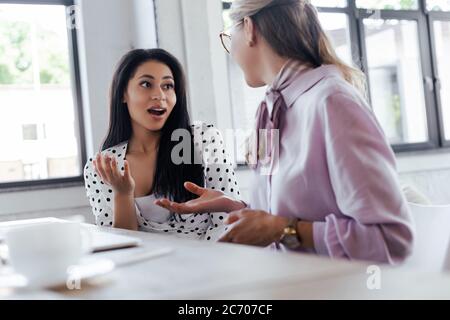 Selektive Konzentration schöner Geschäftsfrauen, die im modernen Büro klatschen Stockfoto