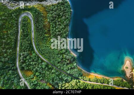 Luftaufnahme Serpentinenstraße und Wald mit Meer Drohnen Landschaft in Norwegen über Bäumen und blauem Meerwasser skandinavische Natur Wildnis Top down Szene Stockfoto