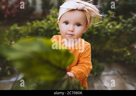Kind kleines Mädchen hält frisch gepflückte Rübe niedliches Baby im Garten gesunde Lebensweise vegane Lebensmittel Bio Sommersaison Stockfoto