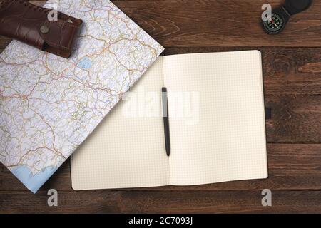 Konzept der Reiseplanung. Reisezubehör. Altes Vintage-Messer mit leerem Notizblock und Kompass auf Holztischhintergrund. Flach liegend, Draufsicht. Stockfoto