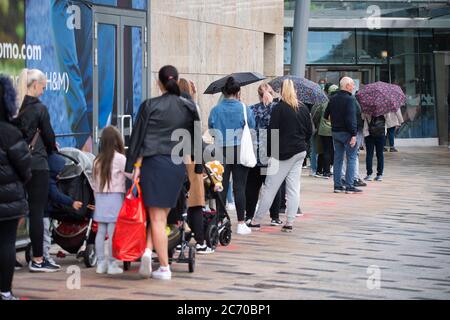 Glasgow, Schottland, Großbritannien. Juli 2020. Im Bild: Die Käufer strömen in Massen zum Einkaufszentrum Silverburn, während sie sich ein Schnäppchen in den Geschäften schnappen. Soziale Distanzierung organisiert und und Gesichtsbedeckungen / Gesichtsmasken getragen, wie es jetzt in Schottland obligatorisch ist. Die Menschen warten geduldig in den langen Warteschlangen im Nieselregen und die Stimmung ist erleichtert, dass die Menschen wieder zu einer Art Normalität der Retail-Therapie. Quelle: Colin Fisher/Alamy Live News Stockfoto
