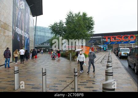Glasgow, Schottland, Großbritannien. Juli 2020. Im Bild: Die Käufer strömen in Massen zum Einkaufszentrum Silverburn, während sie sich ein Schnäppchen in den Geschäften schnappen. Soziale Distanzierung organisiert und und Gesichtsbedeckungen / Gesichtsmasken getragen, wie es jetzt in Schottland obligatorisch ist. Die Menschen warten geduldig in den langen Warteschlangen im Nieselregen und die Stimmung ist erleichtert, dass die Menschen wieder zu einer Art Normalität der Retail-Therapie. Quelle: Colin Fisher/Alamy Live News Stockfoto