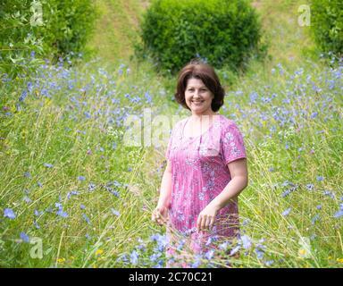 Frau mittleren Alters auf einer schönen wilden Wiese im Sommer Stockfoto