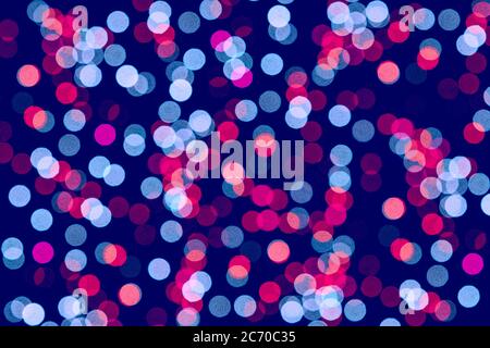 Verschwommenes Licht auf schwarzem Hintergrund. Rosa und blaues Bokeh, festliches Konzept. Stockfoto