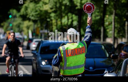 Dresden, Deutschland. Juli 2020. Ein Motorradpolizist winkt bei einer Polizeikontrolle, die prüft, ob bei der Überholung von Radfahrern der Mindestabstand von 1.5 Metern eingehalten wird, einen Polizeikelle zur Seite eines Autofahrers. Mit diesem Sicherheitsprojekt wollen die Polizeidirektion Dresden und der ADFC Sachsen auf die Novellierung der Straßenverkehrsordnung aufmerksam machen, in der spezifische Entfernungsregelungen für Überholungen eingeführt wurden, und die Verkehrsteilnehmer entsprechend sensibilisieren. Quelle: Robert Michael/dpa-Zentralbild/dpa/Alamy Live News Stockfoto