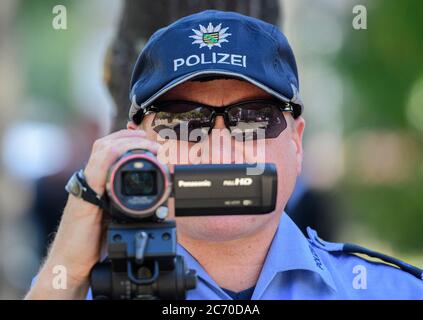 Dresden, Deutschland. Juli 2020. Ein Polizist filmt den Verkehr mit einer Videokamera im Rahmen einer Polizeikontrolle, die prüft, ob bei einem Überholen der Radfahrer die Mindestdistanz von 1.5 Metern eingehalten wird. Mit diesem Sicherheitsprojekt wollen die Polizeidirektion Dresden und der ADFC Sachsen auf die Novelle der Straßenverkehrsordnung aufmerksam machen, in der spezifische Entfernungsregelungen für Überholungen eingeführt wurden, und die Verkehrsteilnehmer entsprechend sensibilisieren. Quelle: Robert Michael/dpa-Zentralbild/dpa/Alamy Live News Stockfoto
