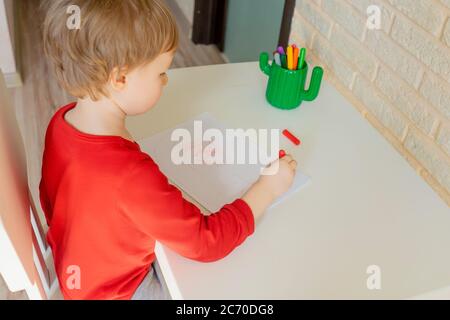 Boy zeichnet mit Filzstift im Album zu Hause. Stockfoto