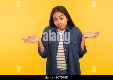 Keine Ahnung, vielleicht! Porträt von verwirrt Mädchen in Denim-Shirt zuckende Schultern in Verwirrung, Zweifel und Gefühl unsicher, weiß nicht, Antwort. Stockfoto