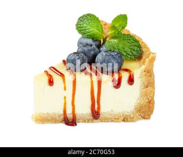 Käsekuchen mit frischen Heidelbeeren, Karamellsirup und Minzblättern isoliert auf weißem Hintergrund. Stockfoto