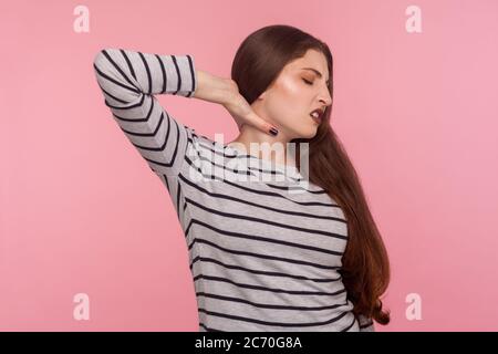 Schmerzende Schultern, steife Muskeln. Portrait von müde kranke Frau im gestreiften Sweatshirt Gefühl unwohl, massieren Halsschmerzen, mit Wirbelsäulenproblemen von OV Stockfoto