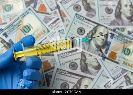 Ärzte oder Krankenschwester Hand hält Spritze auf Geld Hintergrund. Teure Behandlung Konzept. Stockfoto