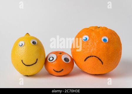 Zitrone, Mandarine und Orange als Familie. Food Charakter mit lustigen Gesichtern auf weißem Hintergrund Stockfoto