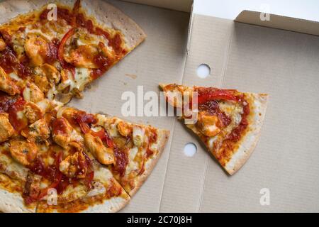 Nahaufnahme würzige New orleans Chicken Flavor Pizza in braunem Papier Tablett Box. Draufsicht Stockfoto