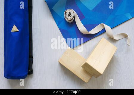 Flach legen von Yoga-Ausrüstung. Blaue Matte, Blöcke und Gürtel auf hellem Hintergrund. Flach liegend. Stockfoto