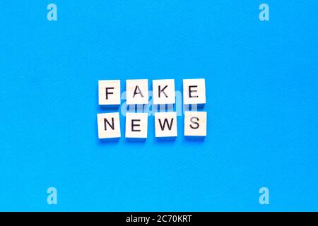 Fake News Wort Alphabet Buchstaben auf blauem Hintergrund. Flaches Layout. Draufsicht. Stockfoto