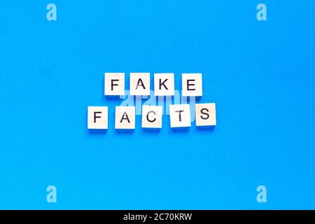 Fake Facts Wort Buchstaben auf blauem Hintergrund. Flaches Layout. Draufsicht. Stockfoto