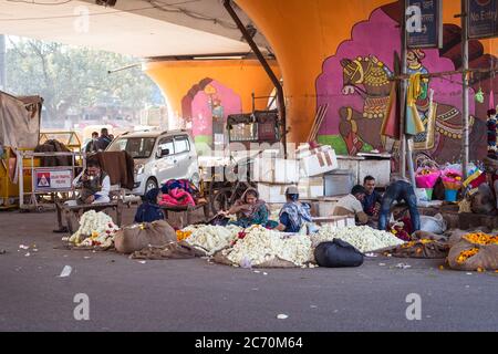 Neu Delhi / Indien - 18. Februar 2020: Menschen verkaufen Blumen unter einer Brücke in Neu Delhi Stockfoto