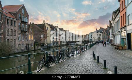 Gent, Belgien - Februar 2018: Malerische mittelalterliche Gebäude mit Blick auf den Graslei-Hafen am Leie-Fluss und dramatischen Sonnenuntergangswolken Stockfoto