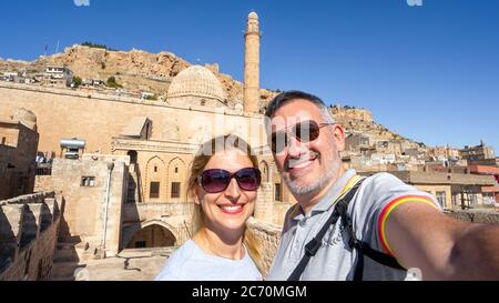 Mardin, Türkei - Januar 2020: Touristen machen ein glückliches Selfie vor dem Ulu Cami, auch bekannt als große Moschee von Mardin Stockfoto