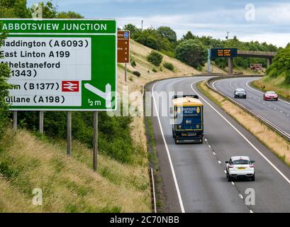 East Lothian, Schottland, Großbritannien, 13. Juli 2020. A1 Covid-19 Reiseberatung Schottland geht in Phase 3 auf einer Überfahrbrücke mit der neuen Iteration der Botschaft: 'Plan ahead, Stay Safe, Save Lives'. Dies ist die vierte Iteration der Coronavirus-Slogans, die von der schottischen Regierung während der Pandemie verwendet wurden. Die zweispurige Straße ist viel geschäftiger und fast wieder auf normale Verkehrsniveaus Stockfoto