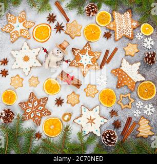 Weihnachts-Ingwerkekse in Form von Schneeflocken, getrockneter Orange, Sternanis und Schneemann auf grauem Steingrund. Draufsicht. Symbole des neuen Jahres und Chr. Stockfoto