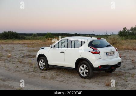 Novoselivka, Dnipropetrovsk Region, Ukraine - 02. juli 2020: Nissan Juke 2019 weiße Farbe in der Nähe der ländlichen Straße in der Dämmerung Stockfoto