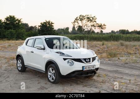 Novoselivka, Dnipropetrovsk Region, Ukraine - 02. juli 2020: Nissan Juke 2019 weiße Farbe in der Nähe der ländlichen Straße in der Dämmerung Stockfoto