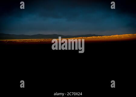 Ein Lichtstrahl beleuchtet die Landschaft, die in einer Entfernung des Safranfeldes von Azafranes Jiloca in Monreal del Campo, Spanien, zu sehen ist. Datum: 28-10-2015. Foto: Xabier Mikel Laburu. José María Plumed und sein Sohn José Ramón bauen, bereiten und verkaufen biologischen Safran über ein kleines Familienunternehmen namens 'Azafranes Jiloca', das 1993 gegründet wurde. Die jährliche Produktion von Safran beträgt ca. 7 kg, die hauptsächlich auf dem internationalen Markt verkauft werden, wobei Belgien mit etwa 45% der Produktion einer der wichtigsten ist. Sie exportieren auch nach Deutschland, ungefähr die 7%. Stockfoto