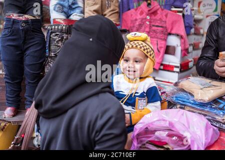 Neu Delhi / Indien - 18. Februar 2020: Muslimische Frau in Niqab und schöner, glücklich lächelnder Sohn im Geschäft in Alt-Delhi Stockfoto