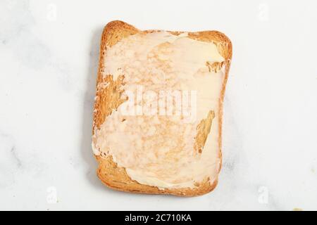 Gebutterte Toastscheiben auf weißem Marmorhintergrund Stockfoto