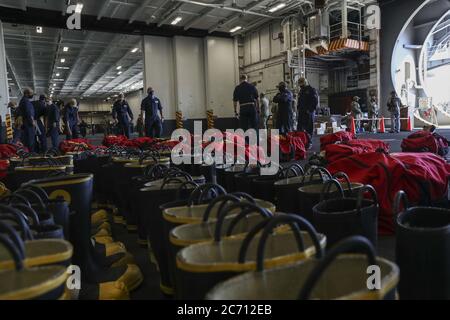 Matrosen, die der USS Abraham Lincoln (CVN 72) zugewiesen wurden, sammeln und inventarisieren Ausrüstung, um die Brandbekämpfung an Bord des amphibischen Angriffsschiffs USS Bonhomme Richard (LHD 6) am 12. Juli 2020 zu unterstützen. Abraham Lincoln ist derzeit an der Naval Air Station North Island vertäut. Am Morgen des 12. Juli wurde ein Feuer an Bord von Bonhomme Richard abgesetzt, während es an der Pier-Seite des Marinestützpunktes San Diego festgemacht wurde. Die Feuerwehr vor Ort, an der Basis und an Bord reagierte auf den Brand. Bonhomme Richard durchläuft eine Wartungsverfügbarkeit, die 2018 begann. Foto von MC3 Darcy McAtee/USA Marine/UPI Stockfoto