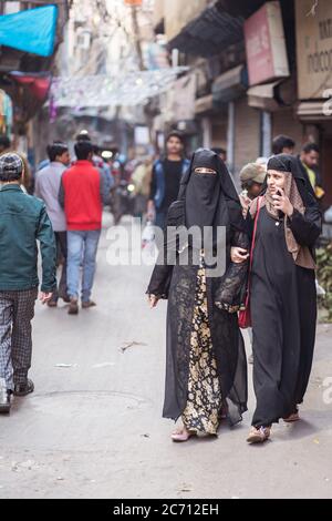 Neu Delhi / Indien - 18. Februar 2020: Junge muslimische Frauen in traditionellen muslimischen Kleidern gehen in den Straßen von Alt-Delhi Stockfoto