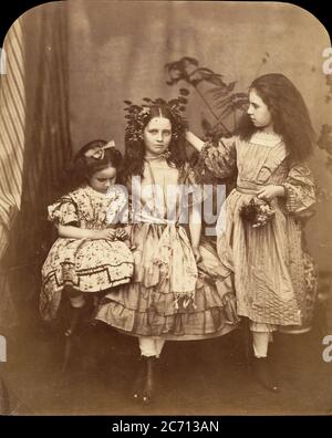 Flora Rankin, Irene MacDonald und Mary Josephine MacDonald in der Elm Lodge, Juli 1863. Irene und Mary MacDonald waren die Kinder des schottischen Schriftstellers und Dichters George MacDonald. Carroll war ein Freund der Familie, und die Kinder nannten ihn liebevoll "Onkel". Dieses Foto, das den in der Mitte stehenden Kinderfreund Flo Rankin zeigt, entstand während des Aufenthalts des Fotografen in der Elm Lodge in Hampstead in der Woche vom 25. Juli 1863. Stockfoto