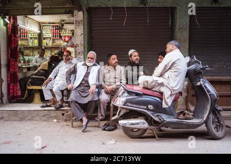 Neu Delhi / Indien - 18. Februar 2020: Gruppe von Musim Männer sitzen vor dem Teeladen in der Straße von Alt-Delhi Stockfoto