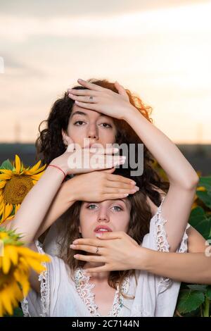 Schöne junge Mädchen posieren in einem Sonnenblumenfeld Stockfoto
