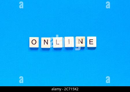 Word Online mit Holzdruckwürfeln auf blauem Hintergrund. ONLINE geschrieben auf Holzwürfeln. Konzeptionell. Online-Geschäft ausbauen. Expandierende Busi Stockfoto