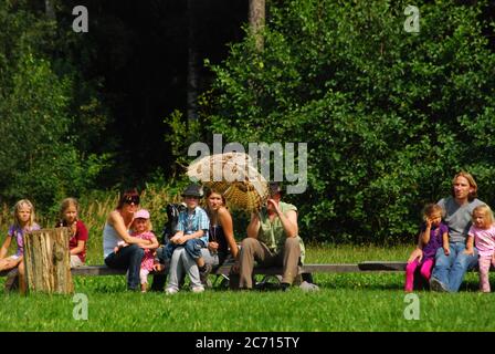 Während einer Falknerei-Show im Zoo beobachten die Menschen eine Eule im Flug Stockfoto