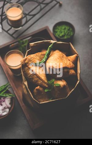 Samosa - Gebratenes Gebäck in Dreieckform mit herzhafter Füllung, beliebte indische Teezeit-Snacks, serviert mit grünem Chutney und Tomatenketchup Stockfoto