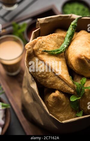 Samosa - Gebratenes Gebäck in Dreieckform mit herzhafter Füllung, beliebte indische Teezeit-Snacks, serviert mit grünem Chutney und Tomatenketchup Stockfoto