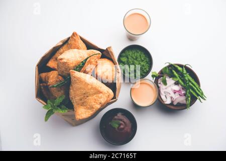 Samosa - Gebratenes Gebäck in Dreieckform mit herzhafter Füllung, beliebte indische Teezeit-Snacks, serviert mit grünem Chutney und Tomatenketchup Stockfoto