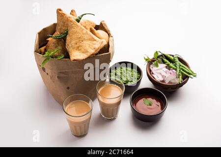 Samosa - Gebratenes Gebäck in Dreieckform mit herzhafter Füllung, beliebte indische Teezeit-Snacks, serviert mit grünem Chutney und Tomatenketchup Stockfoto