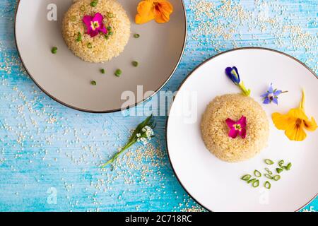 Quinoa-Teller-Präsentation mit essbaren Blumen dekoriert Stockfoto