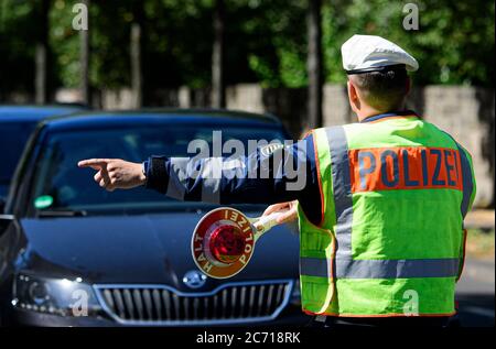 Dresden, Deutschland. Juli 2020. Ein Motorradpolizist winkt bei einer Polizeikontrolle, die prüft, ob bei der Überholung von Radfahrern der Mindestabstand von 1.5 Metern eingehalten wird, einen Polizeikelle zur Seite eines Autofahrers. Mit diesem Sicherheitsprojekt wollen die Polizeidirektion Dresden und der ADFC Sachsen auf die Novellierung der Straßenverkehrsordnung aufmerksam machen, in der spezifische Entfernungsregelungen für Überholungen eingeführt wurden, und die Verkehrsteilnehmer entsprechend sensibilisieren. Quelle: Robert Michael/dpa-Zentralbild/dpa/Alamy Live News Stockfoto