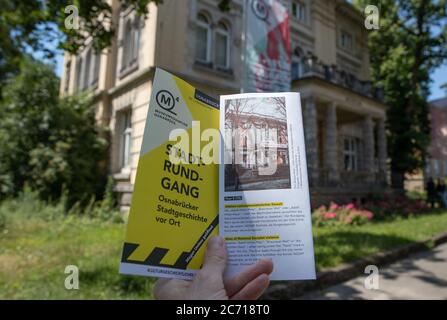 13. Juli 2020, Niedersachsen, Osnabrück: Vor dem jetzigen Gebäude der Villa Schlikker findet ein Flyer "Stadtrundfahrt" statt, auf dem ein Foto der Villa Schlikker aus der NS-Zeit zu sehen ist. Die Stadt will dem Werk des Nazi-Funktionärs Hans Calmeyer in der Villa Schlikker, dem ehemaligen NSDAP-Hauptquartier, eine kritische Würdigung erweisen. Foto: Friso Gentsch/dpa Stockfoto